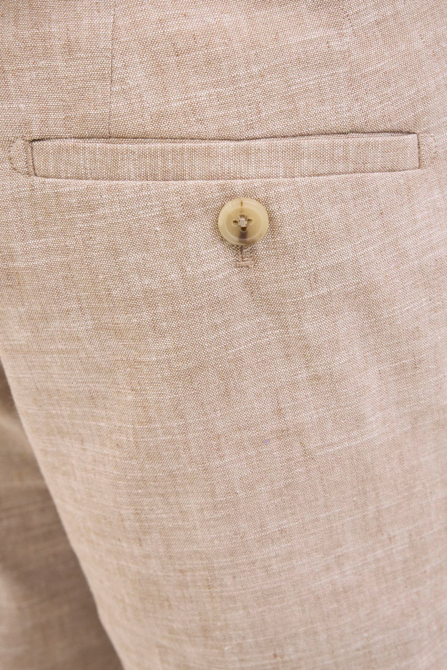Beige linnen broek met zak en knoop.
