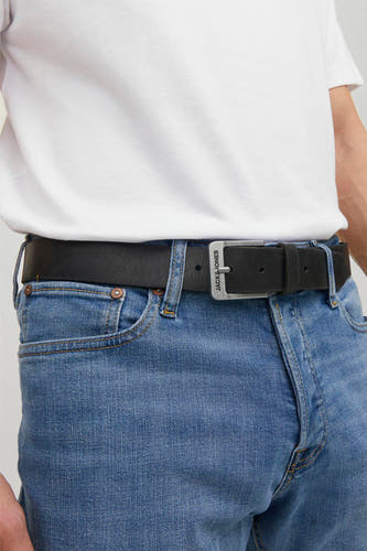 Zwarte riem van ACCESSORIES BY JACK & JONES, gedragen met een witte t-shirt en blauwe jeans.