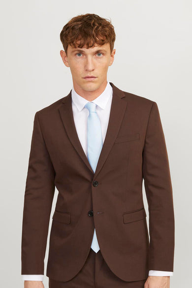Veste bleue d'ACCESSORIES BY JACK & JONES, associée à un manteau brun et une chemise blanche.