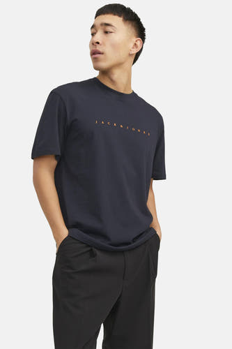 T-shirt bleu à manches courtes d'ORIGINALS BY JACK & JONES, avec un logo orange et porté avec un pantalon noir.