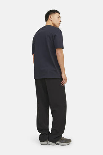 T-shirt bleu à manches courtes d'ORIGINALS BY JACK & JONES, porté avec un pantalon noir et des chaussures grises.