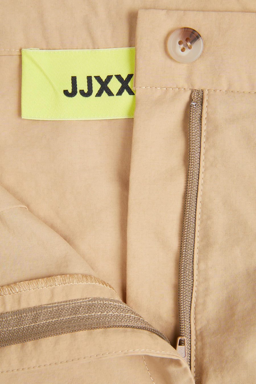 Jupe courte beige de JJXX, avec un nœud et un détail de fermeture éclair.