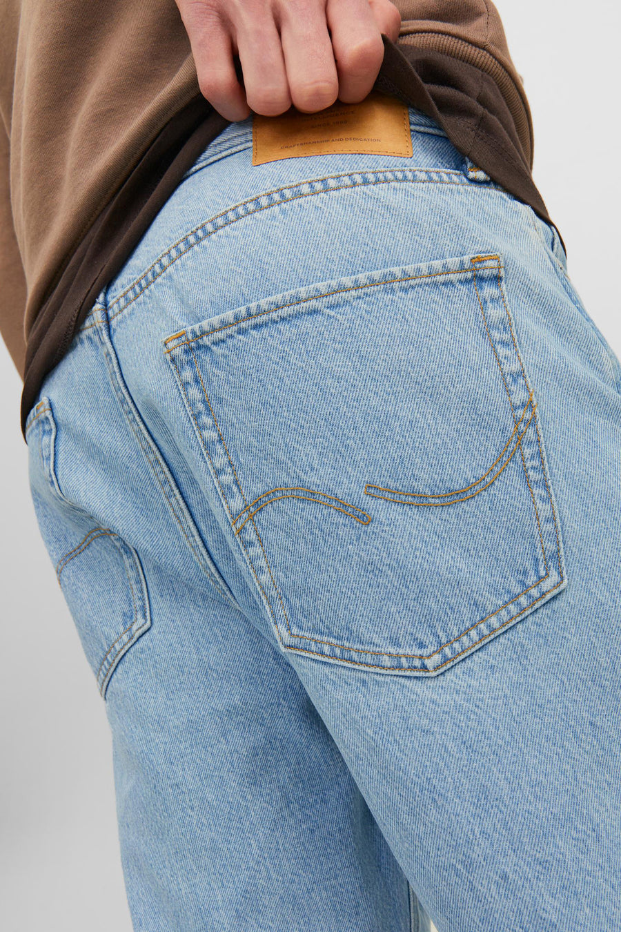 Jean en denim bleu clair large de JACK & JONES JEANS INTELLIGENCE, avec des boutons décoratifs et une patch en cuir.