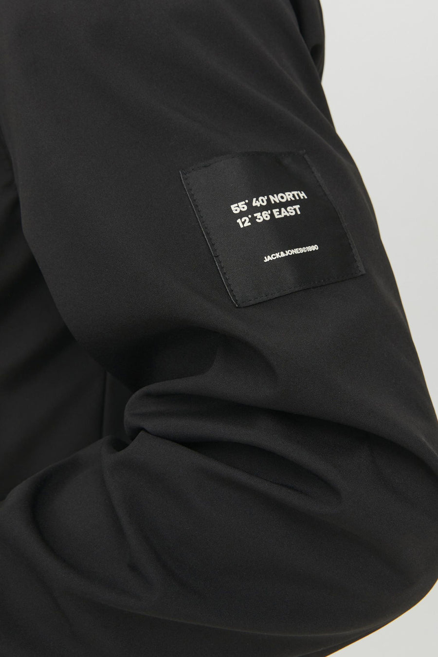 Zwarte stof met een label met coördinaten en het merk "JACK&JONES".