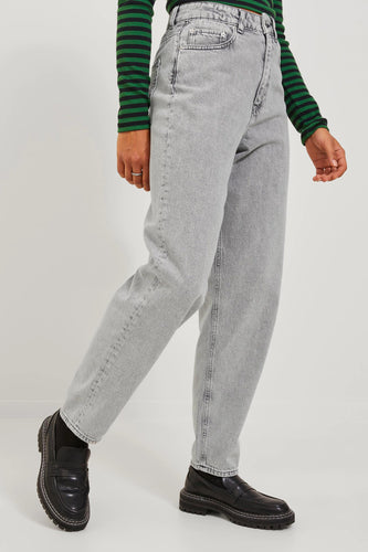 Persoon die grijze jeans en een groen gestreept shirt draagt, met zwarte schoenen.