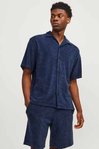 Chemise bleue à manches courtes de PREMIUM by JACK & JONES, vue de derrière, avec un short et des baskets coordonnés.