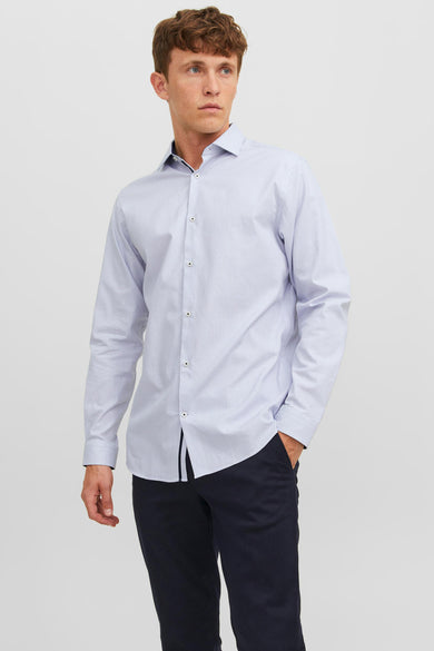 Chemise blanche à manches longues de PREMIUM by JACK & JONES, avec un motif subtil et portée avec un pantalon sombre et des chaussures.