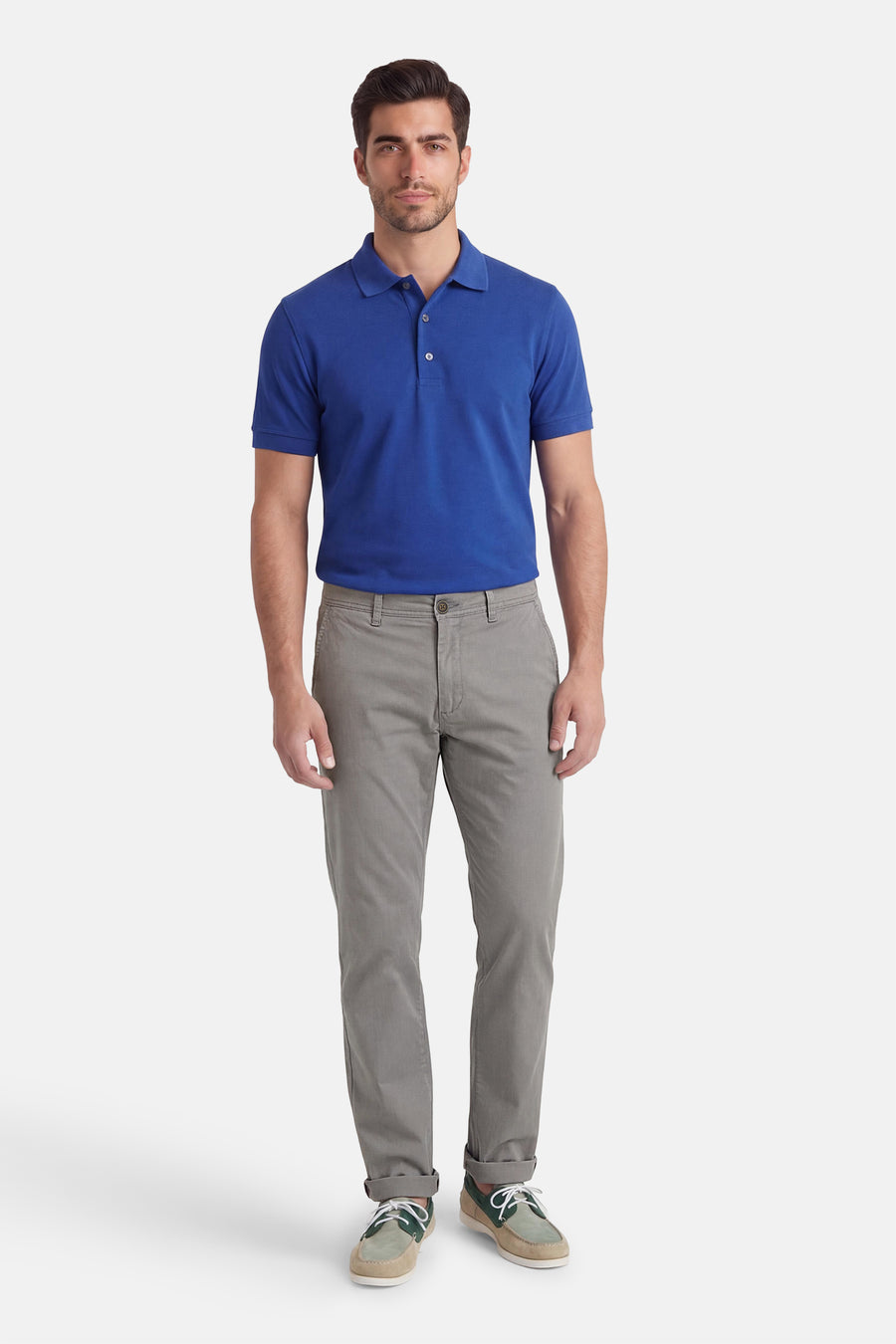 Grijze chino van Jack & Jones Jeans Intelligence, met opgerolde pijpen en gedragen met een blauw poloshirt en bruine schoenen.