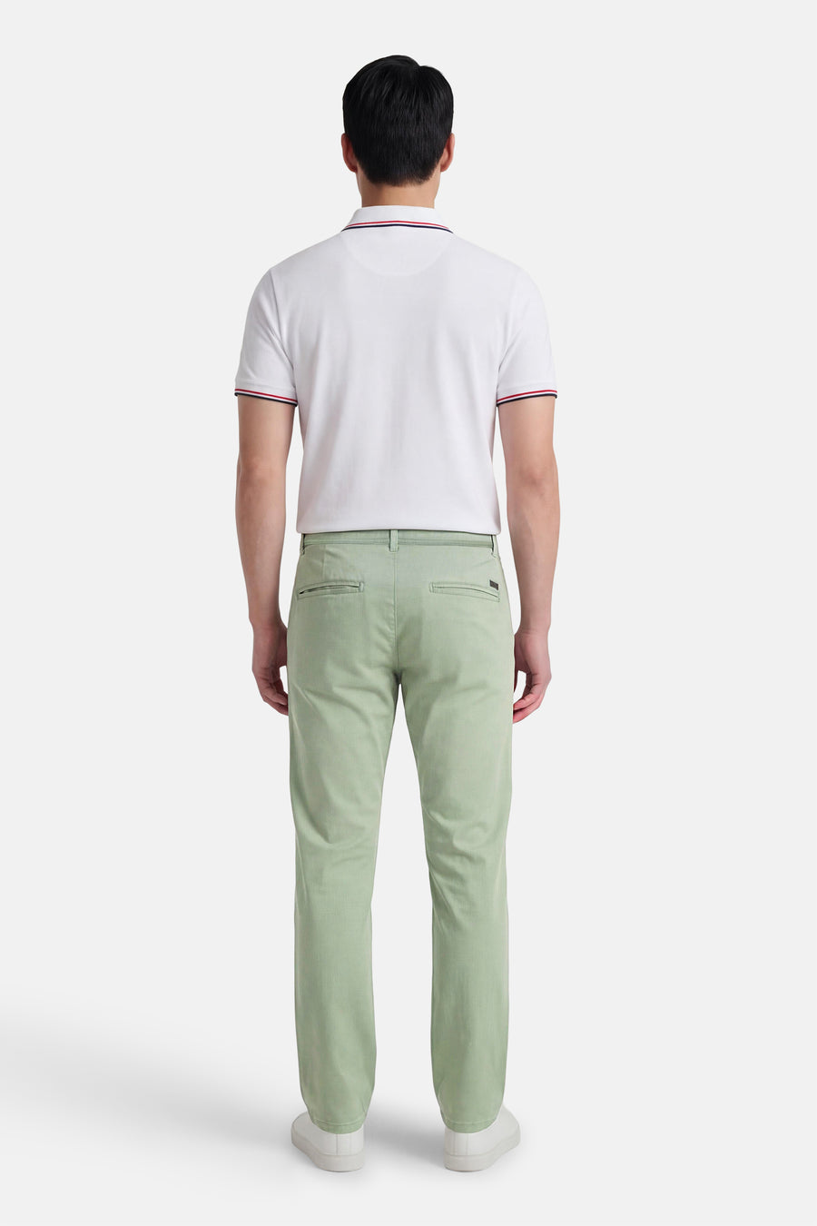 Pantalon chino vert de JACK & JONES JEANS INTELLIGENCE, vu de dos, combiné avec un polo blanc et des chaussures blanches.