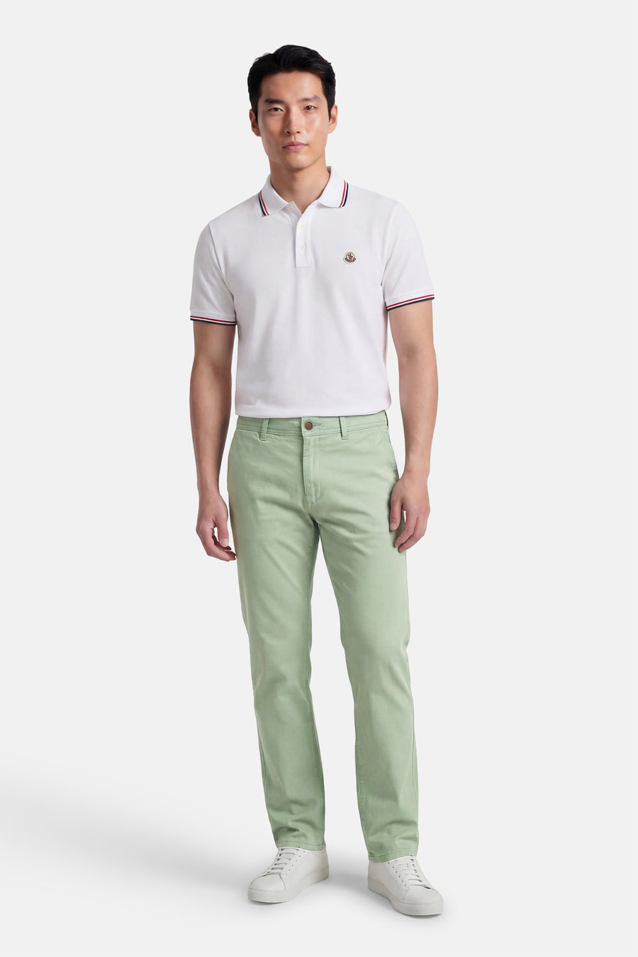 Chino vert kaki de JACK & JONES JEANS INTELLIGENCE, avec jambes droites et fermeture à boutons, combiné avec un polo blanc et des baskets blanches.