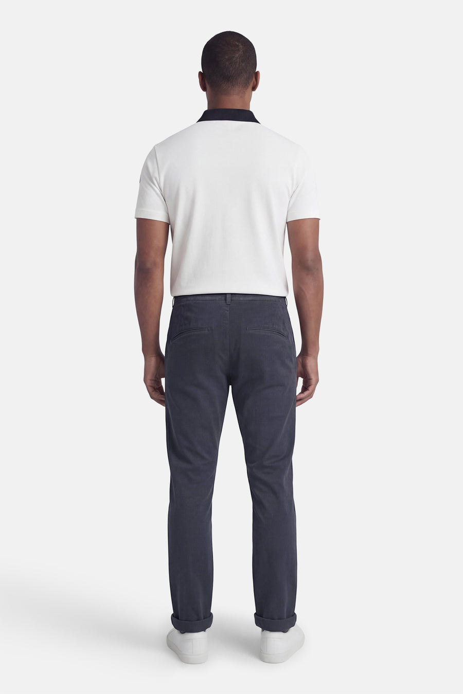 Chino bleu de JACK & JONES JEANS INTELLIGENCE, avec ourlets retroussés et chaussures blanches.
