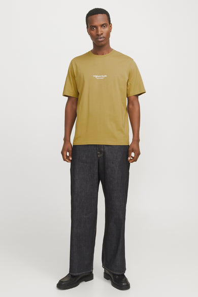 T-shirt vert de mantes courtes manSSS BY & & JONES, porté avec des jeans foncés et des chaussures noires.