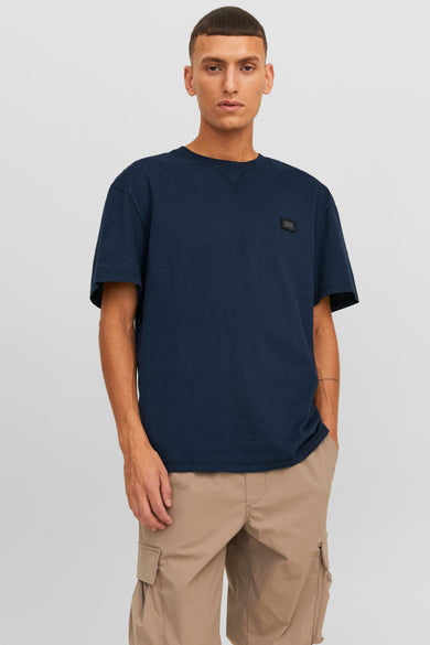 T-shirt à manches courtes bleu marine de CORE BY JACK & JONES avec petite étiquette sur la poitrine, porté par un mannequin dans une photo lifestyle
