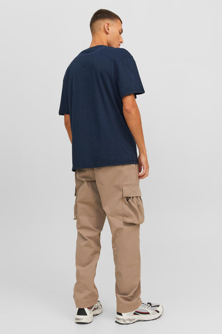 T-shirt à manches courtes bleu marine de CORE BY JACK & JONES, dos visible sur un mannequin portant un pantalon cargo beige et des baskets