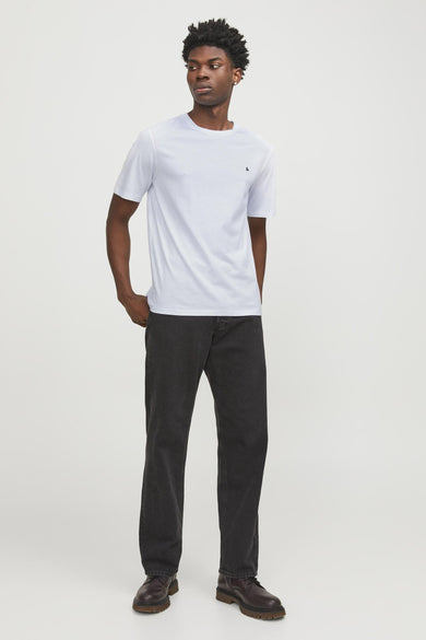 T-shirt blanc à manches courtes d'ORIGINALS BY JACK & JONES, porté avec des jeans noirs et des chaussures marrons.