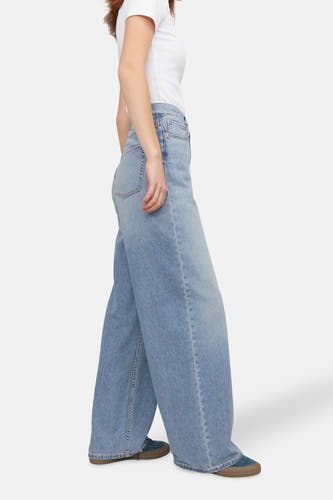 Jean en denim bleu clair large de JJXX, avec une coupe décontractée et porté avec un T-shirt blanc.