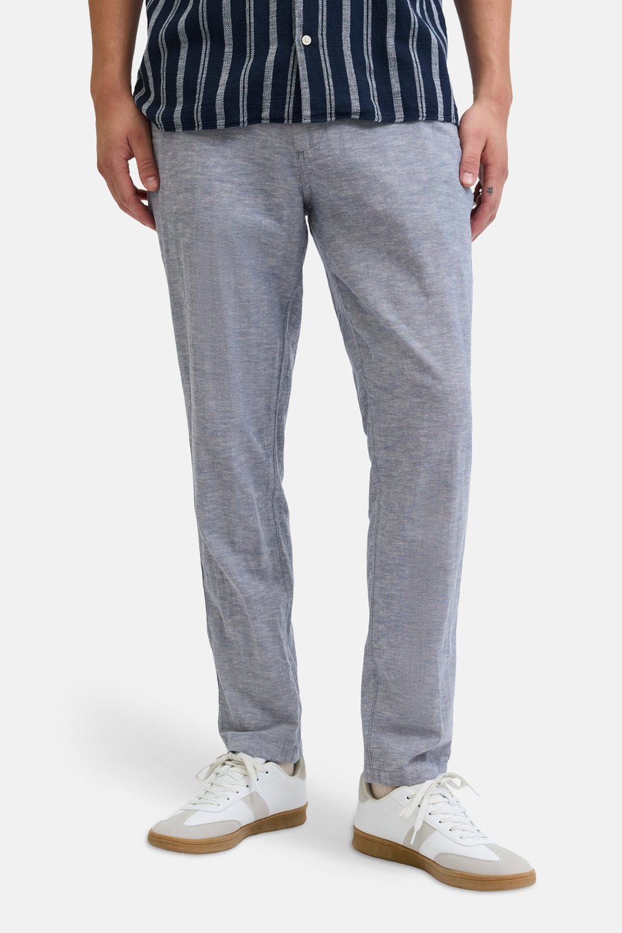 Chino bleu de JACK & JONES JEANS INTELLIGENCE, porté avec une chemise rayée et des baskets blanches.