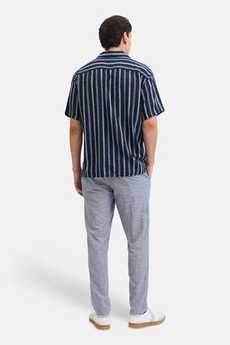 Chino bleu de JACK & JONES JEANS INTELLIGENCE, avec une texture légère, combiné avec une chemise rayée et des baskets blanches.