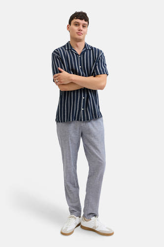 Chino bleu de JACK & JONES JEANS INTELLIGENCE, combiné avec une chemise rayée et des baskets blanches.