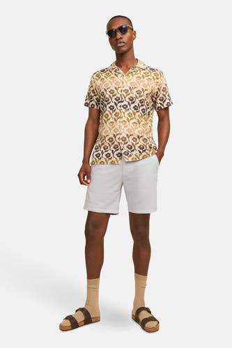 Short beige de JACK & JONES JEANS INTELLIGENCE, combiné avec un chemisier à fleurs, des chaussettes et des sandales.