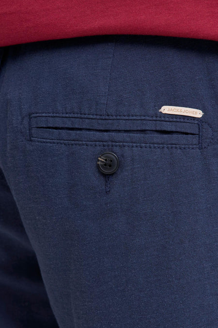 Short bleu en tissu tissé de JACK & JONES JEANS INTELLIGENCE avec poche arrière, bouton et étiquette marron clair, surmonté d'un T-shirt rouge.