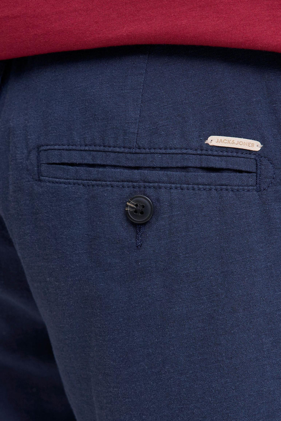Short bleu en tissu tissé de JACK & JONES JEANS INTELLIGENCE avec poche arrière, bouton et étiquette marron clair, surmonté d'un T-shirt rouge.