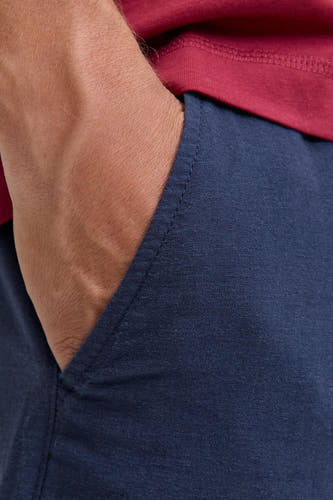 Short bleu de JACK & JONES JEANS INTELLIGENCE avec texture aspect lin, poche latérale et t-shirt rouge.