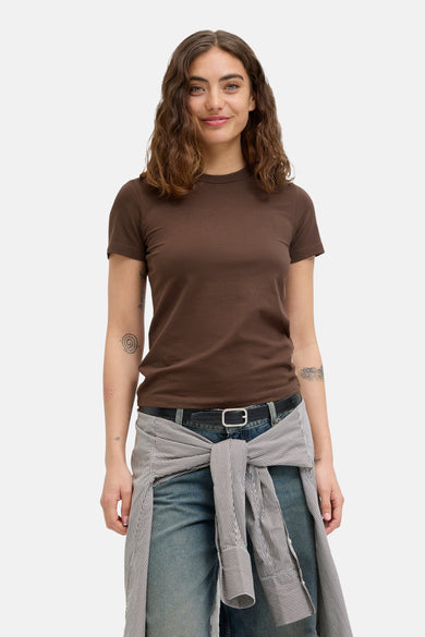 T-shirt marron à manches courtes de JJXX, avec une blouse rayée décontractée autour de la taille et des jeans bleus.