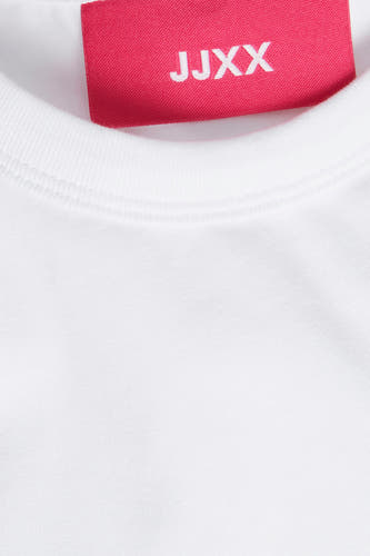 Wit T-shirt met korte mouwen van JJXX, close-up van de halslijn met een roze merklabel.
