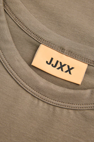 Bruin T-shirt met korte mouwen van JJXX, close-up van de halslijn met merklabel en stiksels.