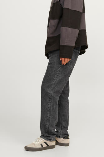 Jean délavé large de JACK & JONES JEANS INTELLIGENCE, avec un effet stonewashed, associé à une chemise rayée noire et grise.