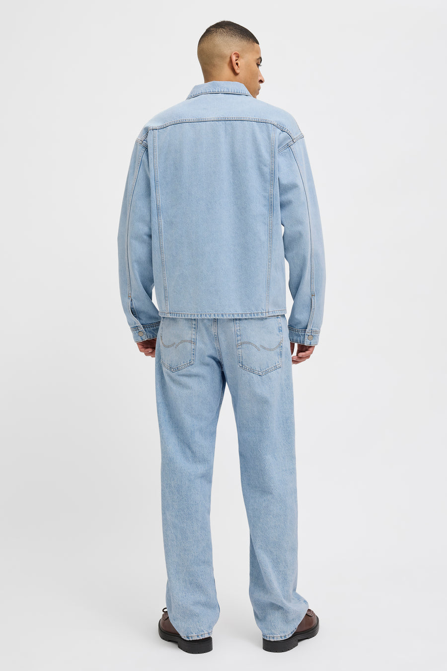 Jeanshemd van lichtblauw denim van JACK & JONES JEANS INTELLIGENCE, gezien van achteren met bijpassende jeans en bruine schoenen.