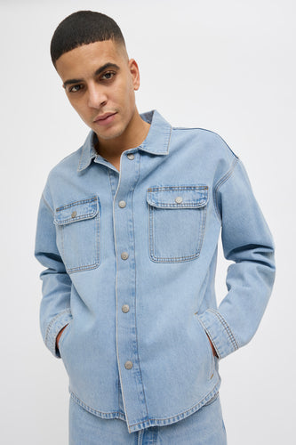 Jeanshemd in lichtblauw denim van JACK & JONES JEANS INTELLIGENCE, met borstzakken en lange mouwen, model met handen in de zakken.
