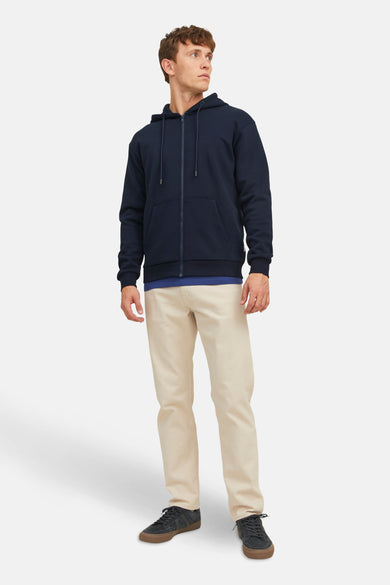 Blauw vest van CORE BY JACK & JONES, met lange mouwen en een capuchon, gedragen over een blauw shirt en beige broek.
