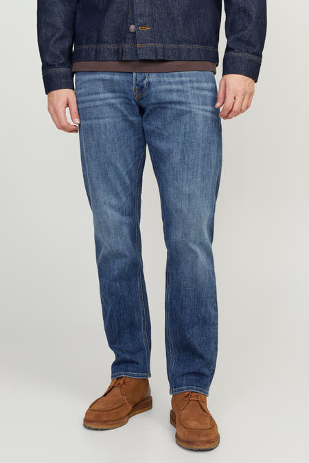 Jean tapered bleu de JACK & JONES JEANS INTELLIGENCE, associé à des chaussures en cuir marron et une veste denim bleu marine.