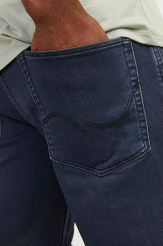 Donkerblauwe jeansshort van JACK & JONES JEANS INTELLIGENCE, met zichtbare achterzak en een hand in de zak.
