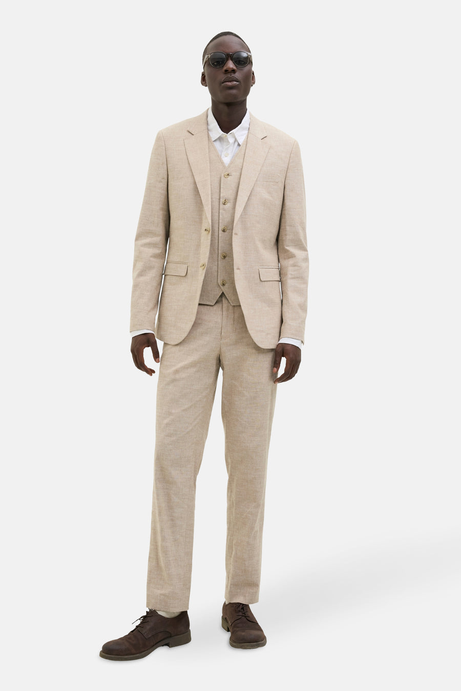 Beige gilet van PREMIUM by JACK & JONES, gedragen met een bijpassend pak en bruine schoenen.