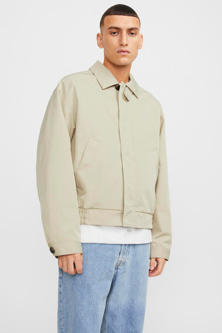 Blouson écru court d'ORIGINALS BY JACK & JONES, avec des manches longues et porté avec des jeans et un T-shirt.