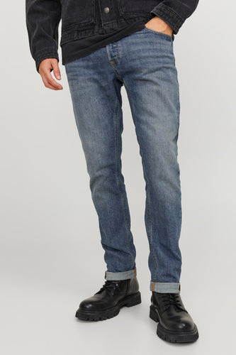 Man met blauwe jeans, zwarte jas en zwarte boots.