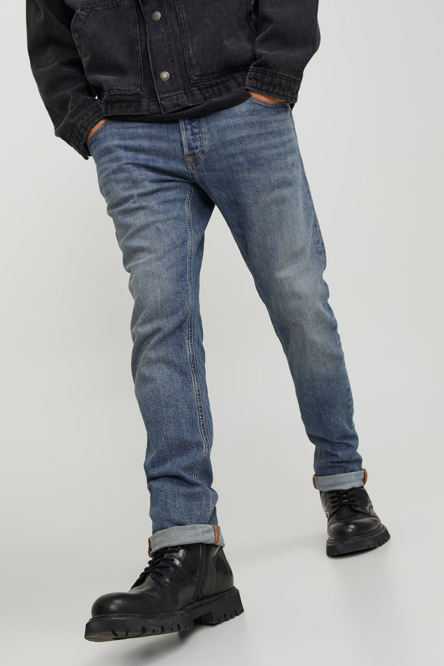 Man in blauwe jeans en zwarte boots.