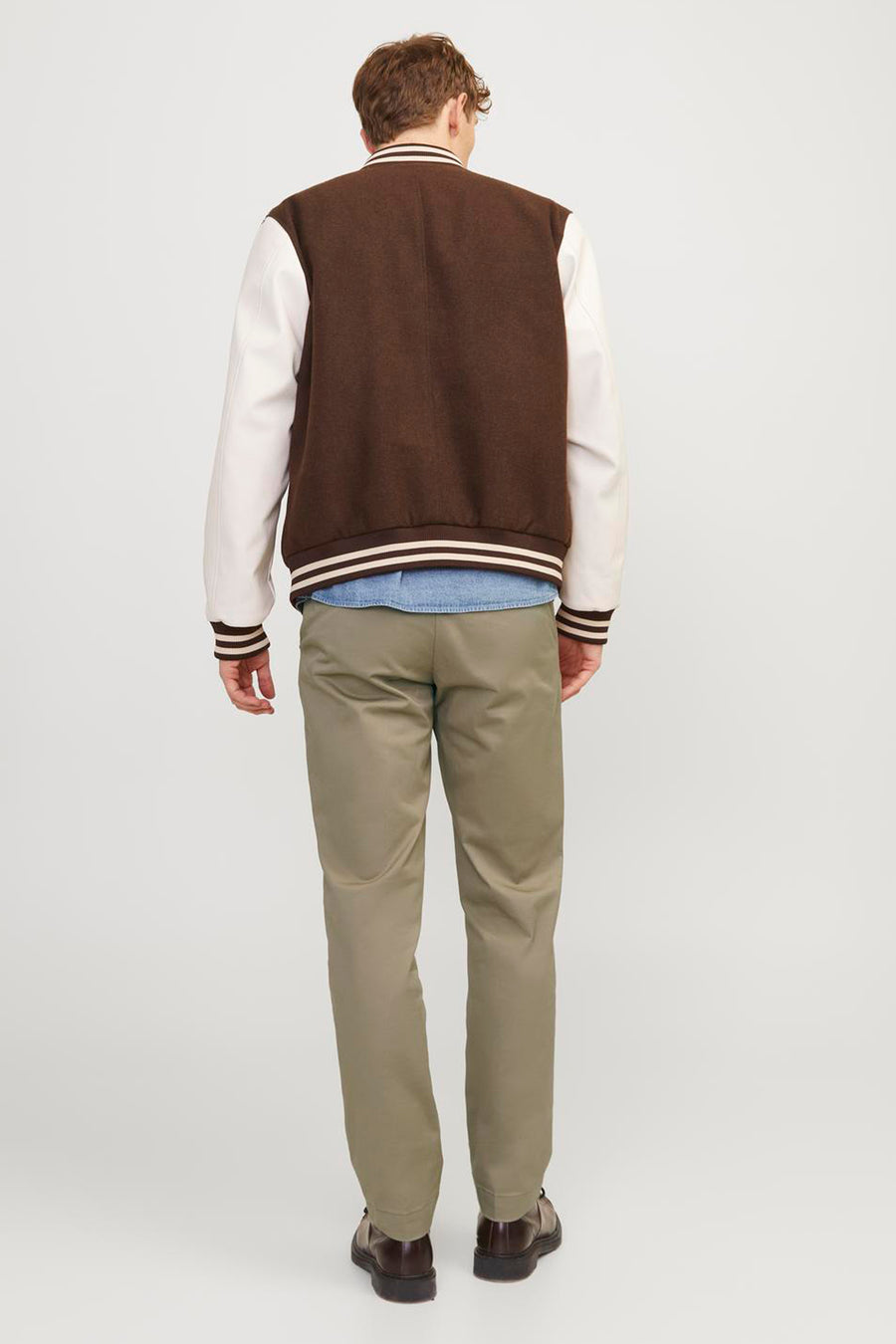 Chino beige de JACK & JONES JEANS INTELLIGENCE, vu de dos avec un blouson universitaire et des chaussures marron.