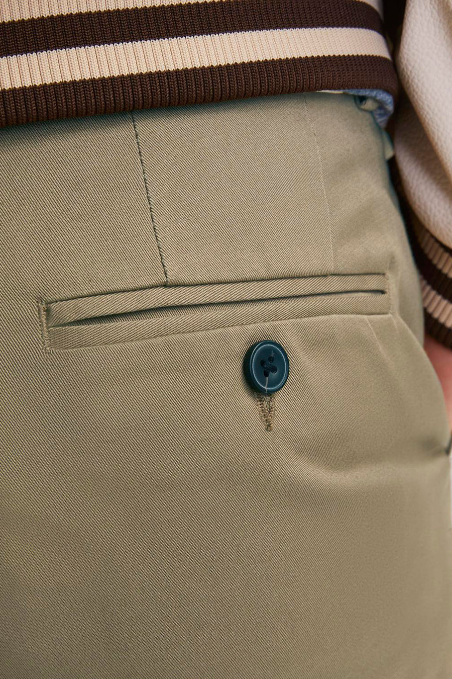 Chino beige en twill de JACK & JONES JEANS INTELLIGENCE, avec poche passepoilée, bouton bleu foncé et bordure rayée.