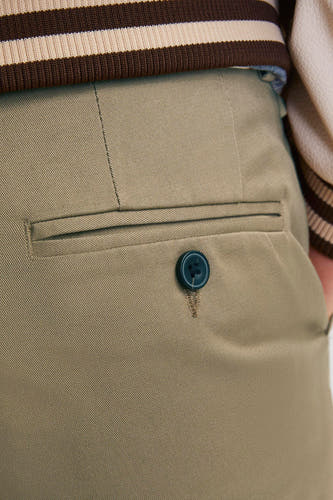 Chino beige de JACK & JONES JEANS INTELLIGENCE avec poche arrière et bouton bleu foncé.