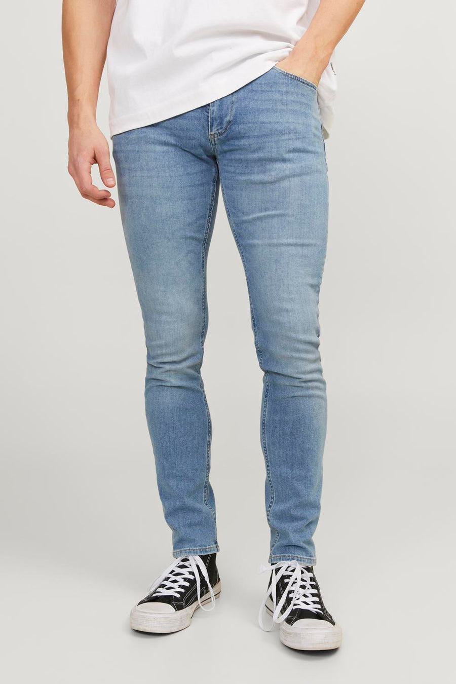 Jean skinny bleu clair de JACK & JONES JEANS INTELLIGENCE, porté avec des baskets noires et un T-shirt blanc.