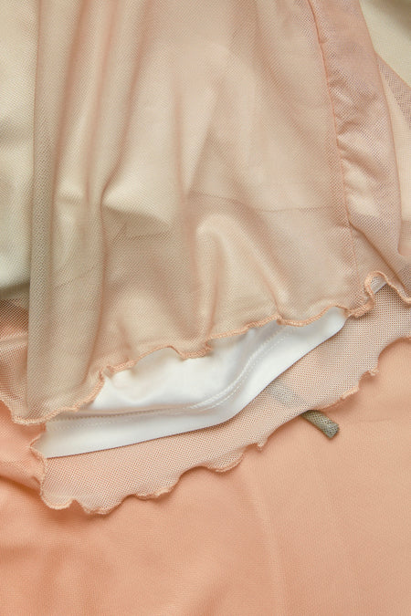 Long jupe rose de JJXX, avec un overlay mesh transparent et une bordure ondulée, détail.