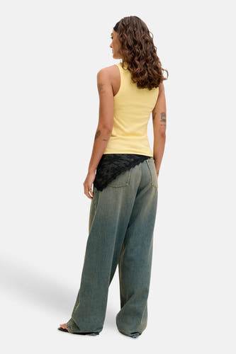 Haut jaune de JJXX, avec un design sans manches et un style avec un jean ample et un bandeau noir.