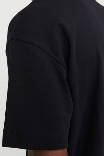 T-shirt noir à manches courtes de CORE BY JACK & JONES, image coupée avec un focus sur le détail du épaule.