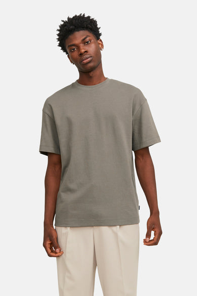 T-shirt vert de manteses courtes CORE BY JACK & JONES, porté avec un pantalon beige.