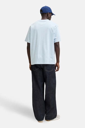 T-shirt bleu à manches courtes de CORE BY JACK & JONES, vu de dos, avec un pantalon foncé et une casquette bleue.