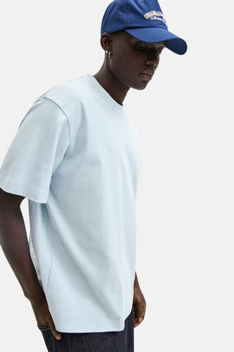T-shirt bleu à manches courtes de CORE BY JACK & JONES, porté avec un chapeau bleu et une pantalon en denim.